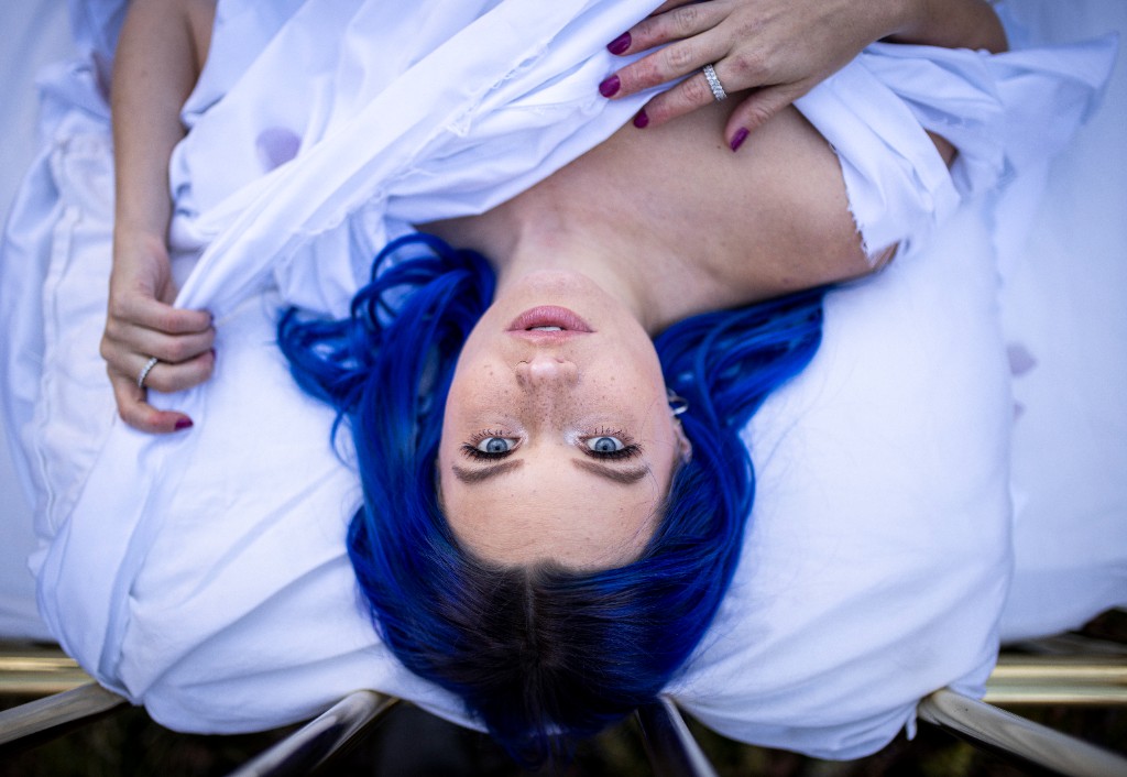 Three-quarter portrait with rose and blue hair in forest